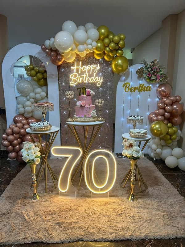 Elegant 70th birthday decoration in Hyderabad with white and gold balloons, LED numbers, and cake setup by Hyderabadi Events.