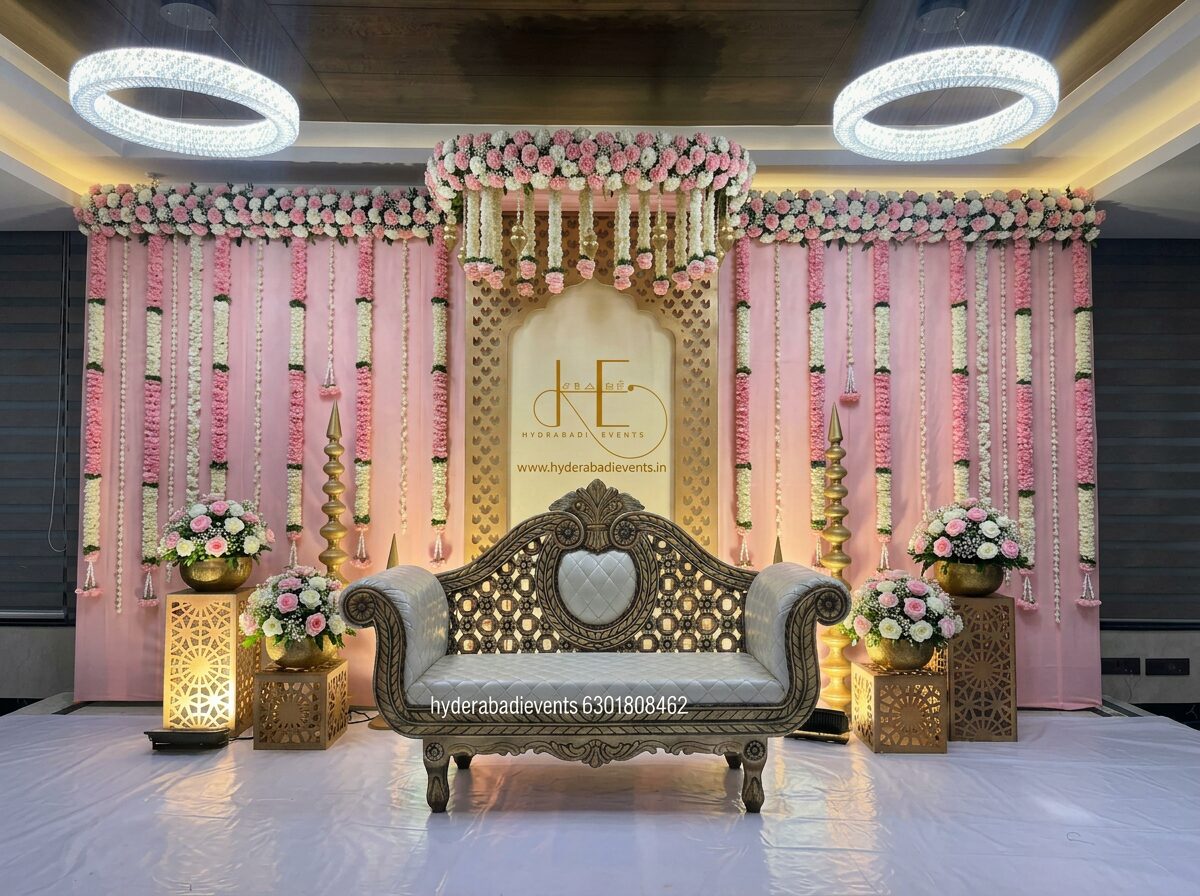 Luxury pink floral naming ceremony stage with hanging flowers, designer backdrop and royal sofa seating.