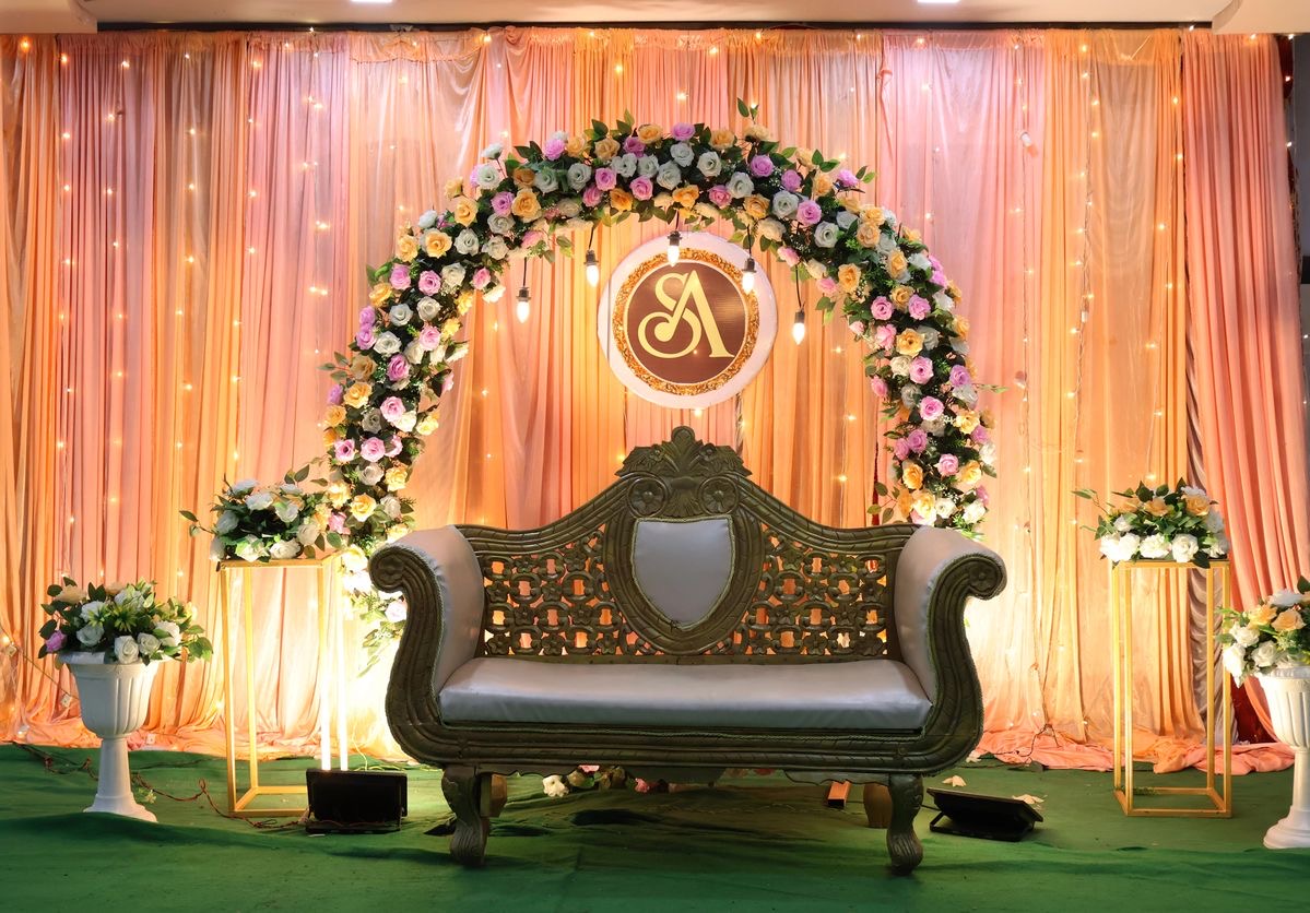 Romantic red and ivory floral ring engagement stage decoration with designer couch and hanging bulb lighting