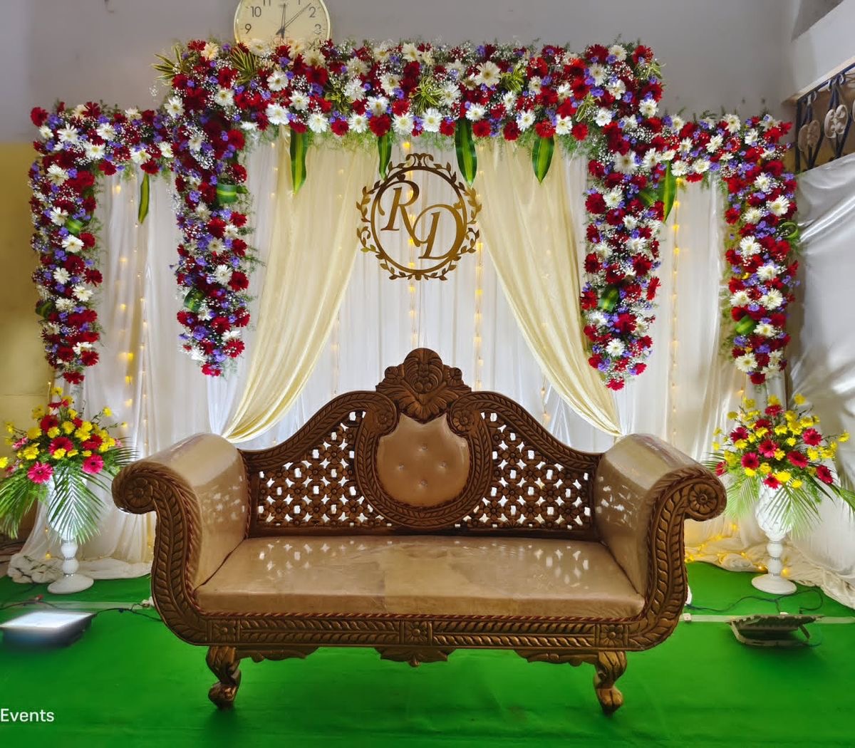 Royal purple floral reception stage decoration with chandelier lighting and classic carved sofa setup