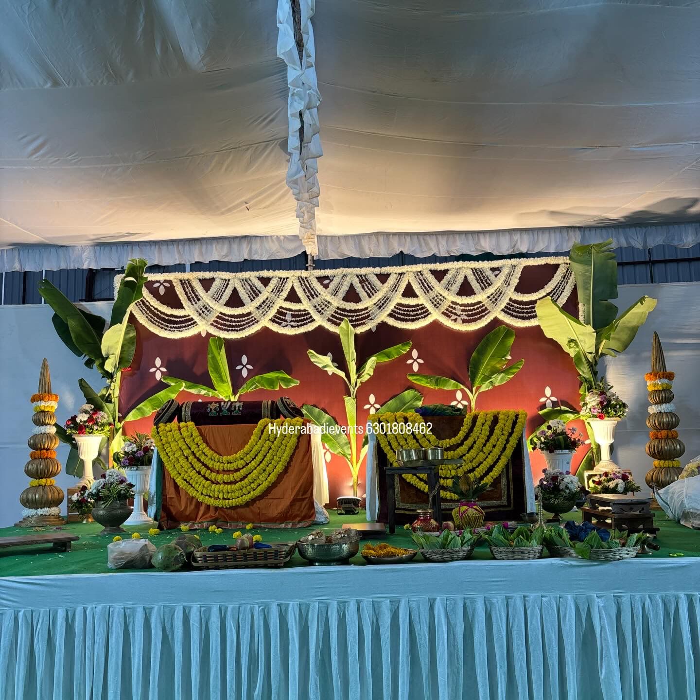 Traditional pooja decoration with banana leaves, garlands and ceremonial setup.