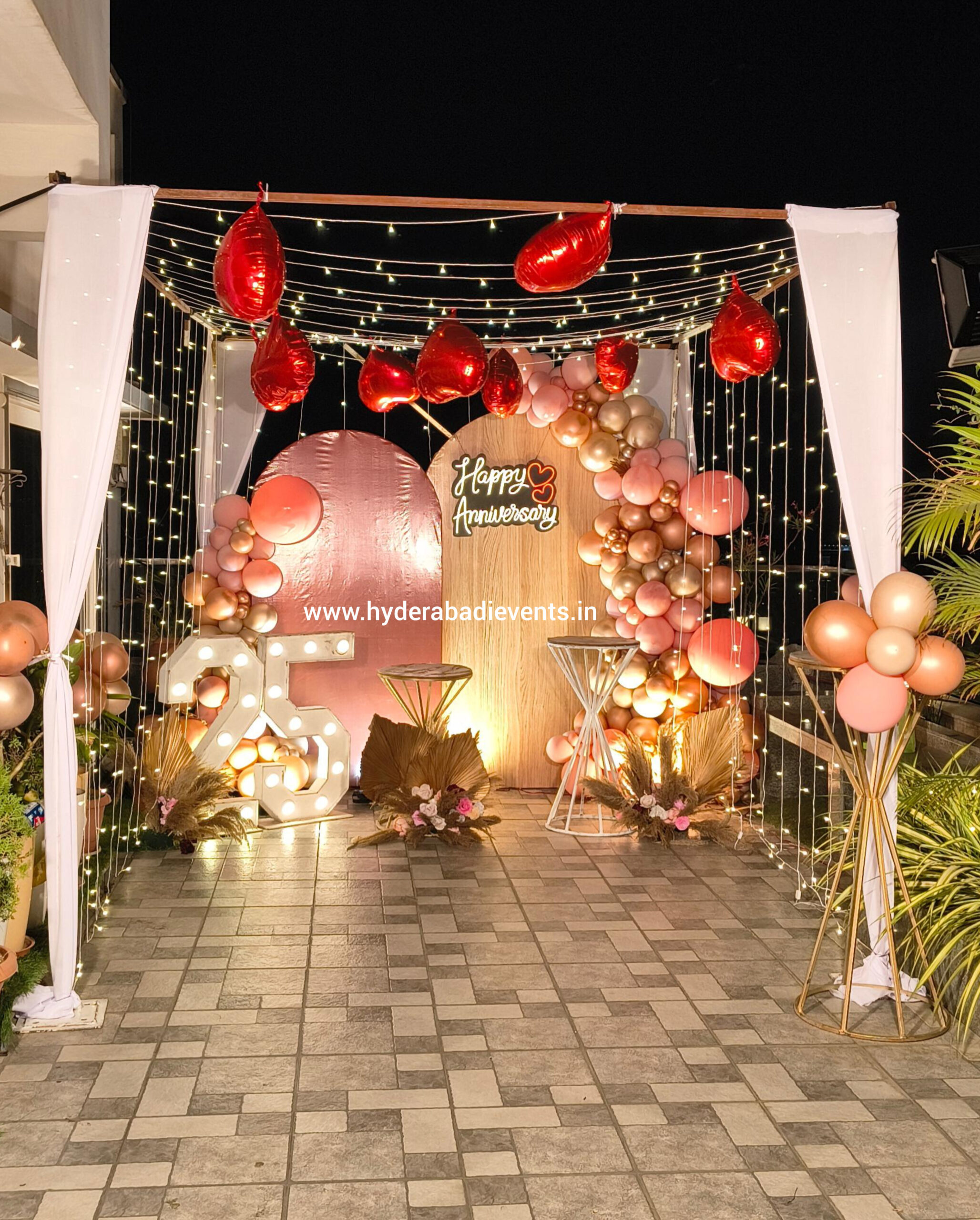 Romantic anniversary cabana decoration with fairy lights, heart balloons, LED numbers and balloon backdrop for couple celebration in Hyderabad.