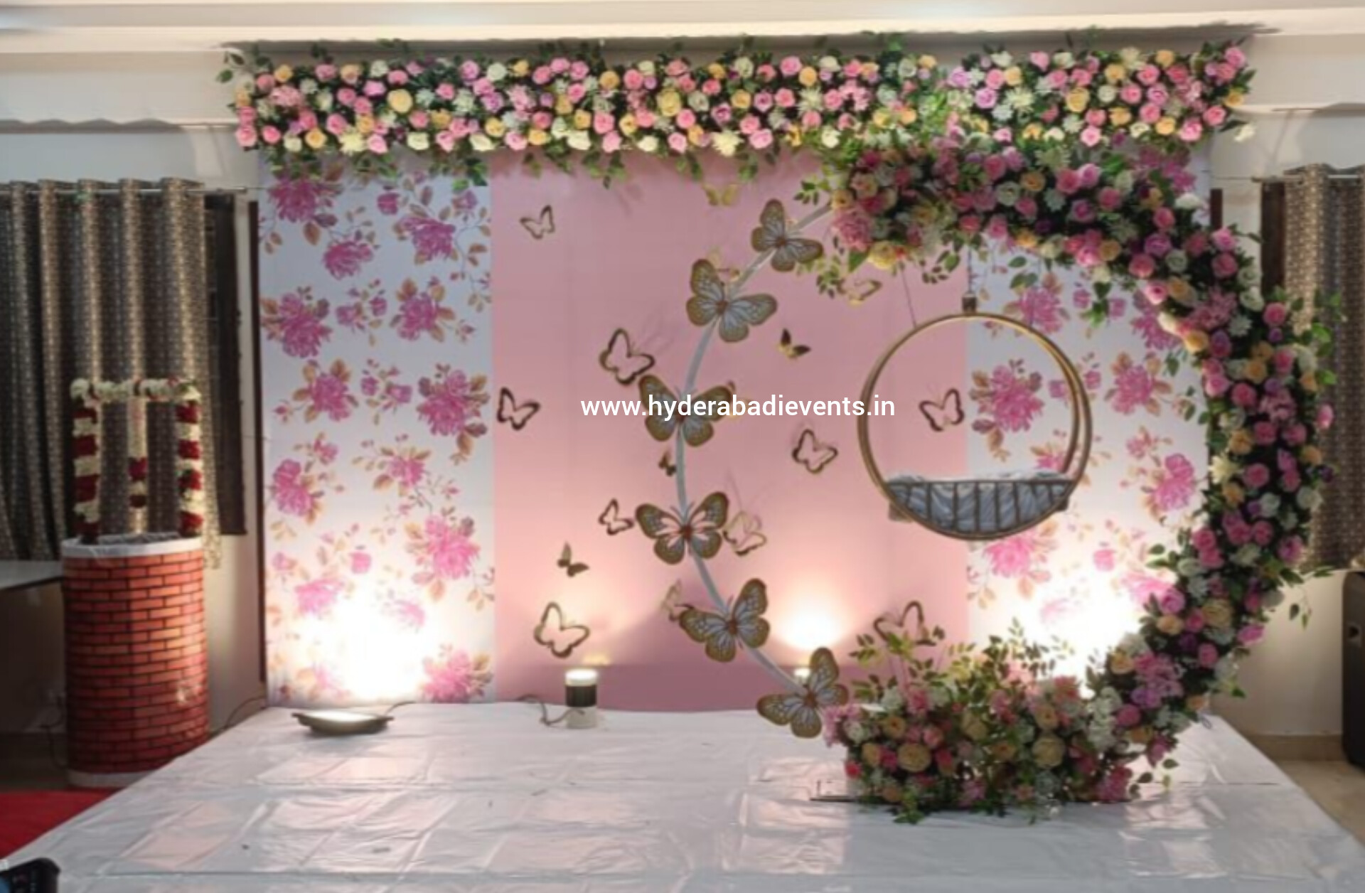 Floral butterfly themed backdrop with pink design and swing decoration for events in Hyderabad.