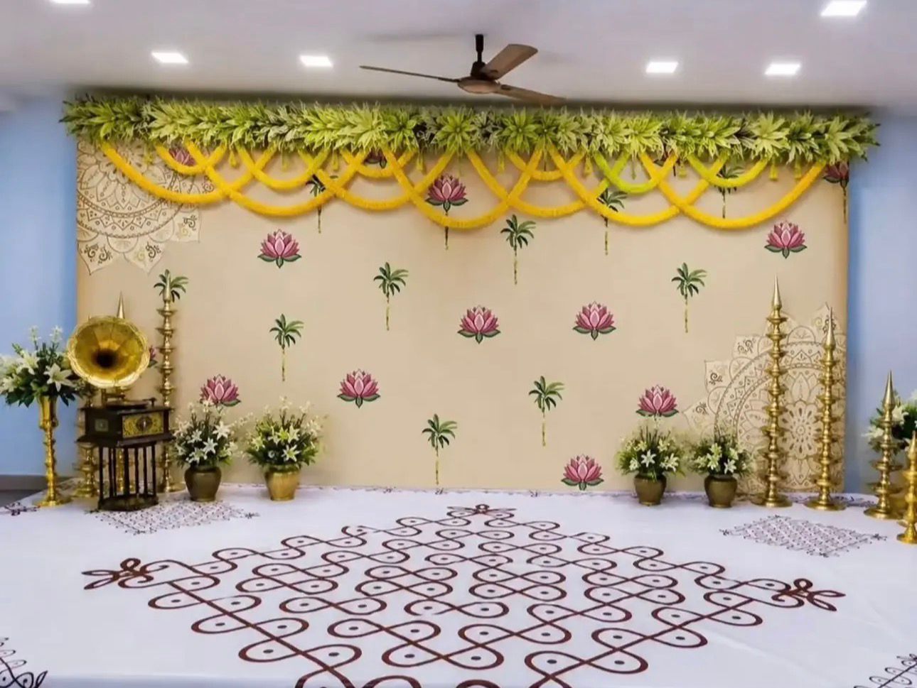 Traditional lotus backdrop decoration with brass lamps and floral arrangements