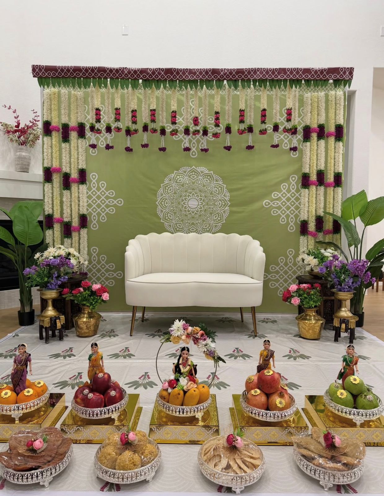 Green traditional Seemantham backdrop decoration with floral garlands and cultural setup