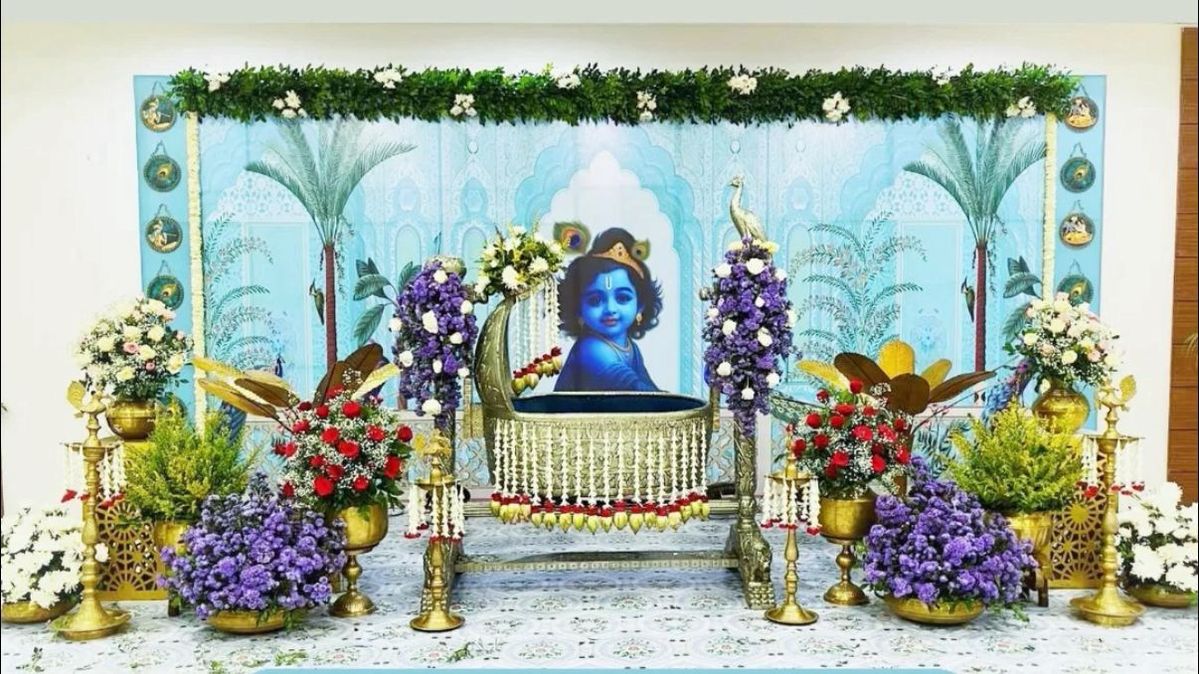 Luxury Krishna cradle ceremony decoration with floral arrangements and premium baby event stage setup