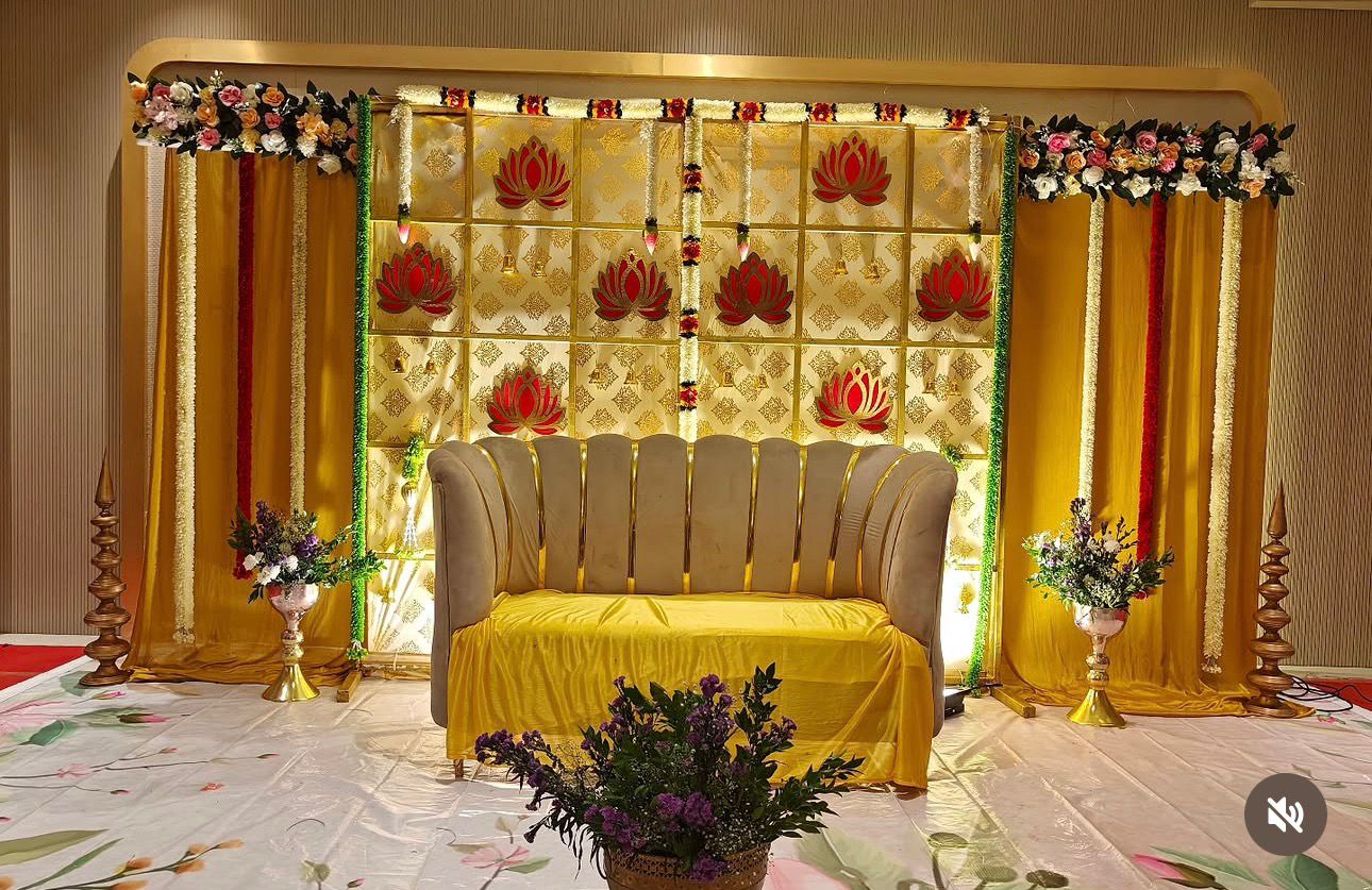 Luxury golden lotus Seemantham decoration with premium sofa, floral hangings and elegant golden backdrop in Hyderabad.
