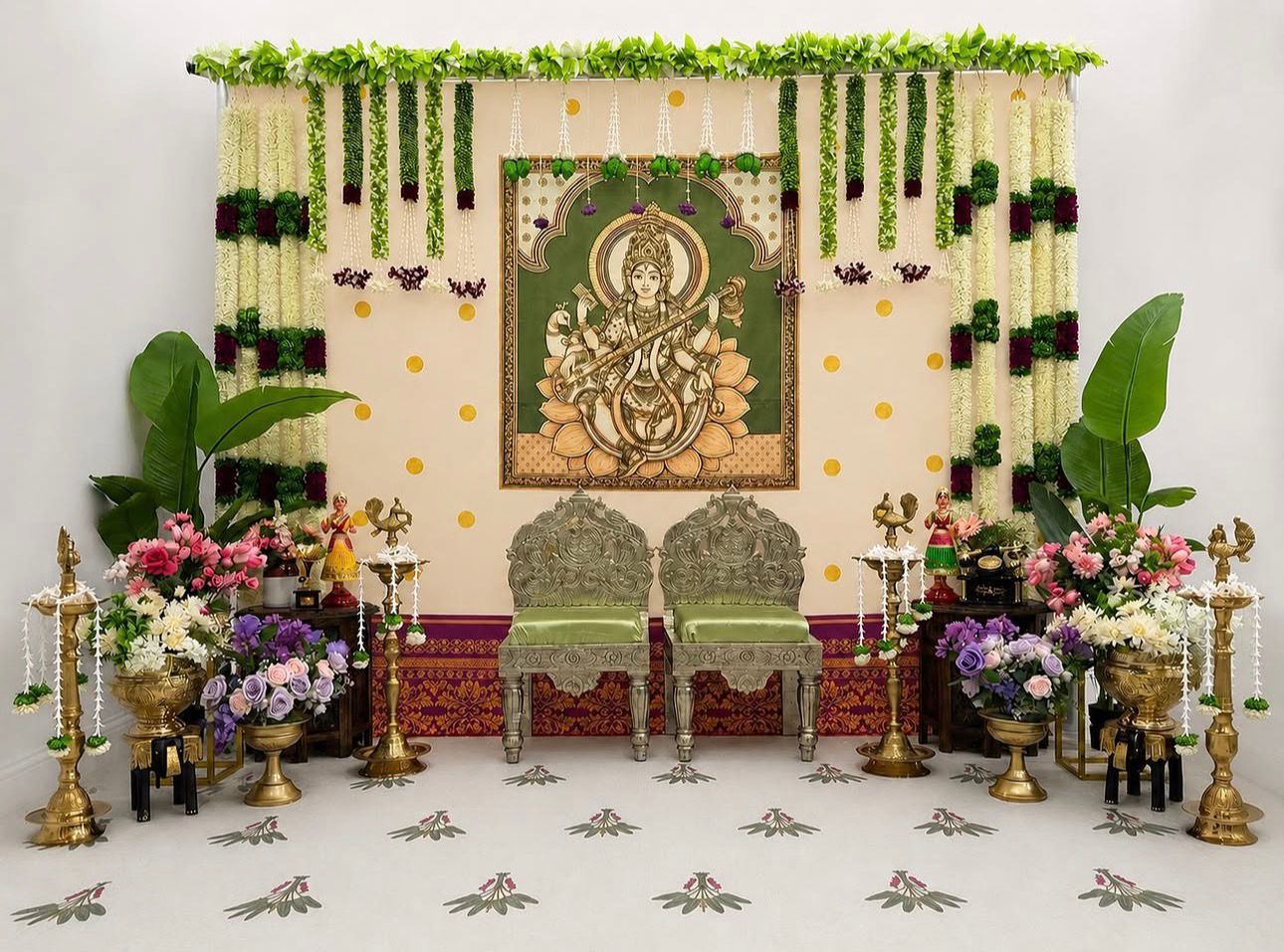 Saraswati theme Seemantham decoration with floral backdrop, silver chairs, jasmine garlands, banana leaves and traditional South Indian baby shower décor.