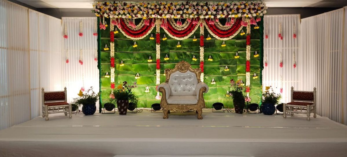 Traditional banana leaf Seemantham stage decoration with fresh banana leaves, jasmine garlands, floral canopy and royal chair.